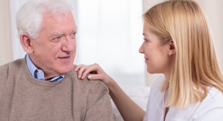 Retiree and senior care assistant talking together